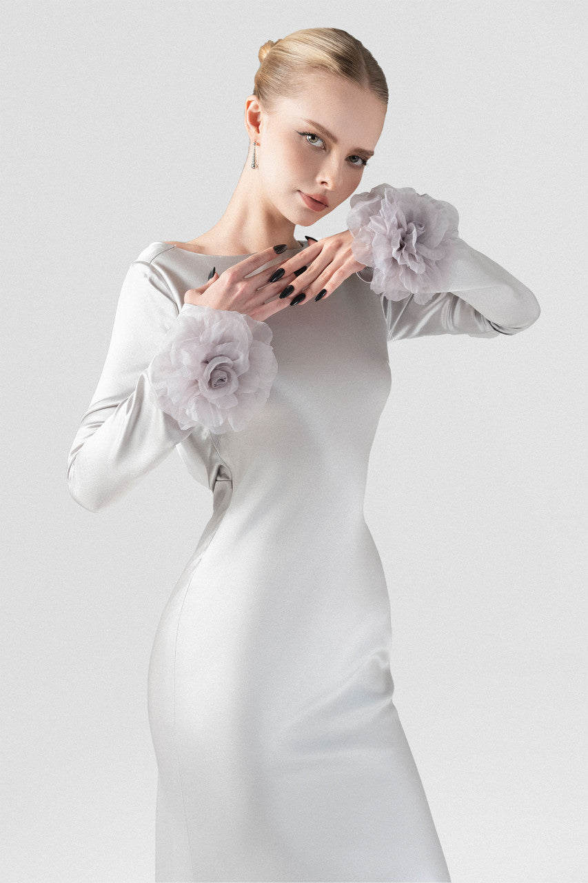 The grey silk maxi dress with mermaid silhouette, plunging open back, and handcrafted floral details at the hem and cuffs.