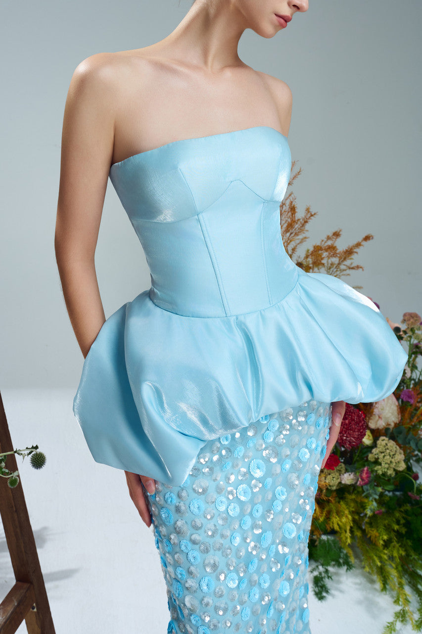 A blue sequin dress with corset bodice, peplum design and sparkling silver embellishments.