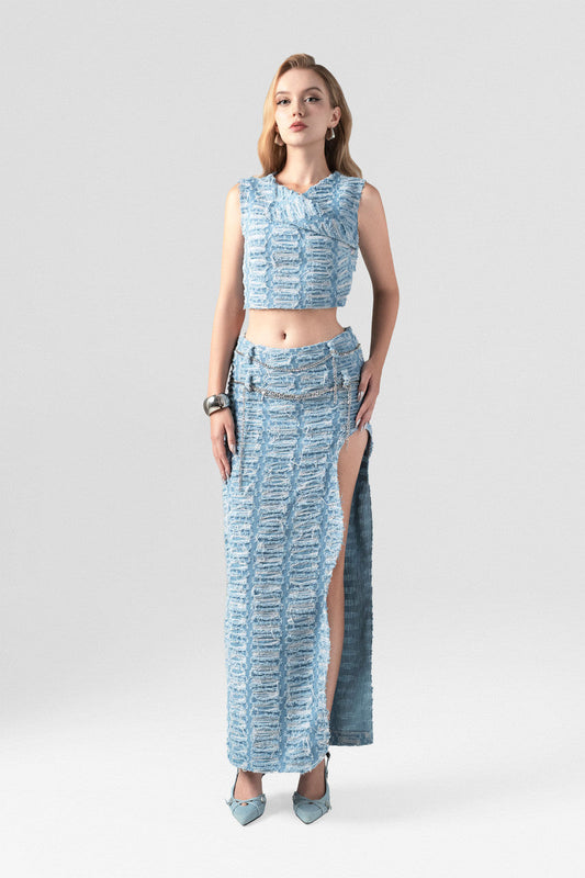 Denim set in blue hue, featuring a sleeveless crop top and a high-waisted floor-length skirt with a thigh-high slit.