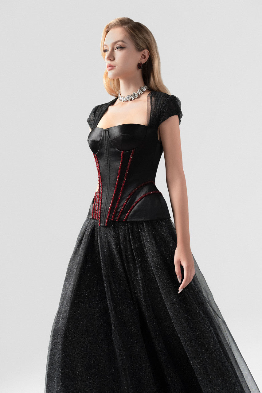 A black evening dress in sequin and taffeta, embellished with a rhinestone row at the waist.