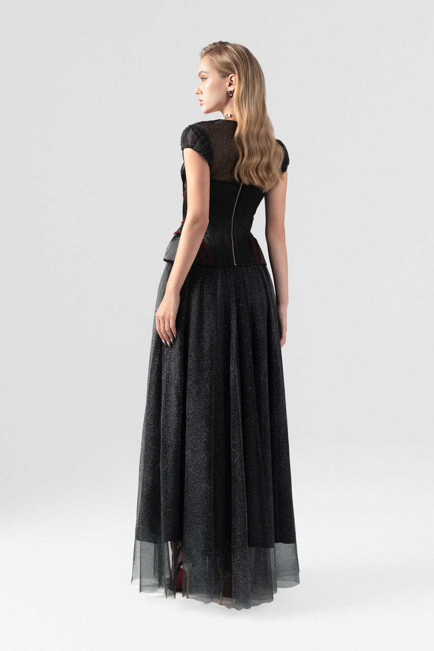 The back of this black dress features a structured corset-style bodice with a layered sheer skirt.