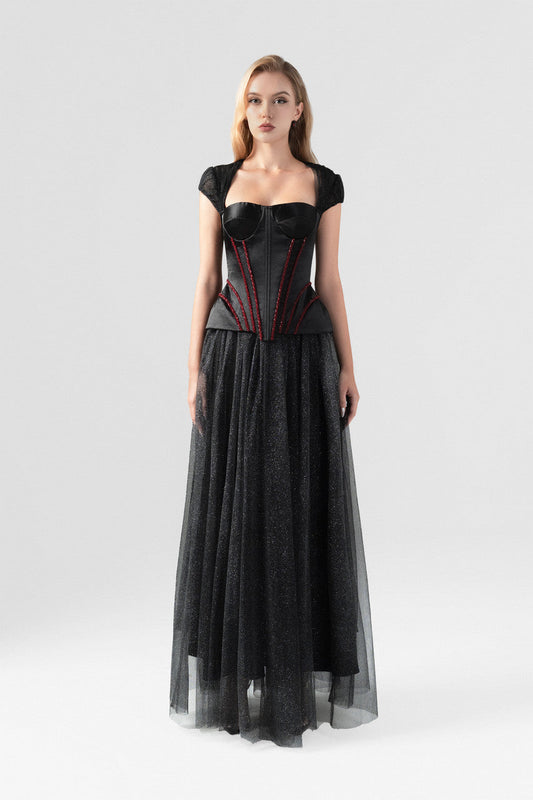 A  black evening dress in sequin and taffeta, embellished with a rhinestone row at the waist.