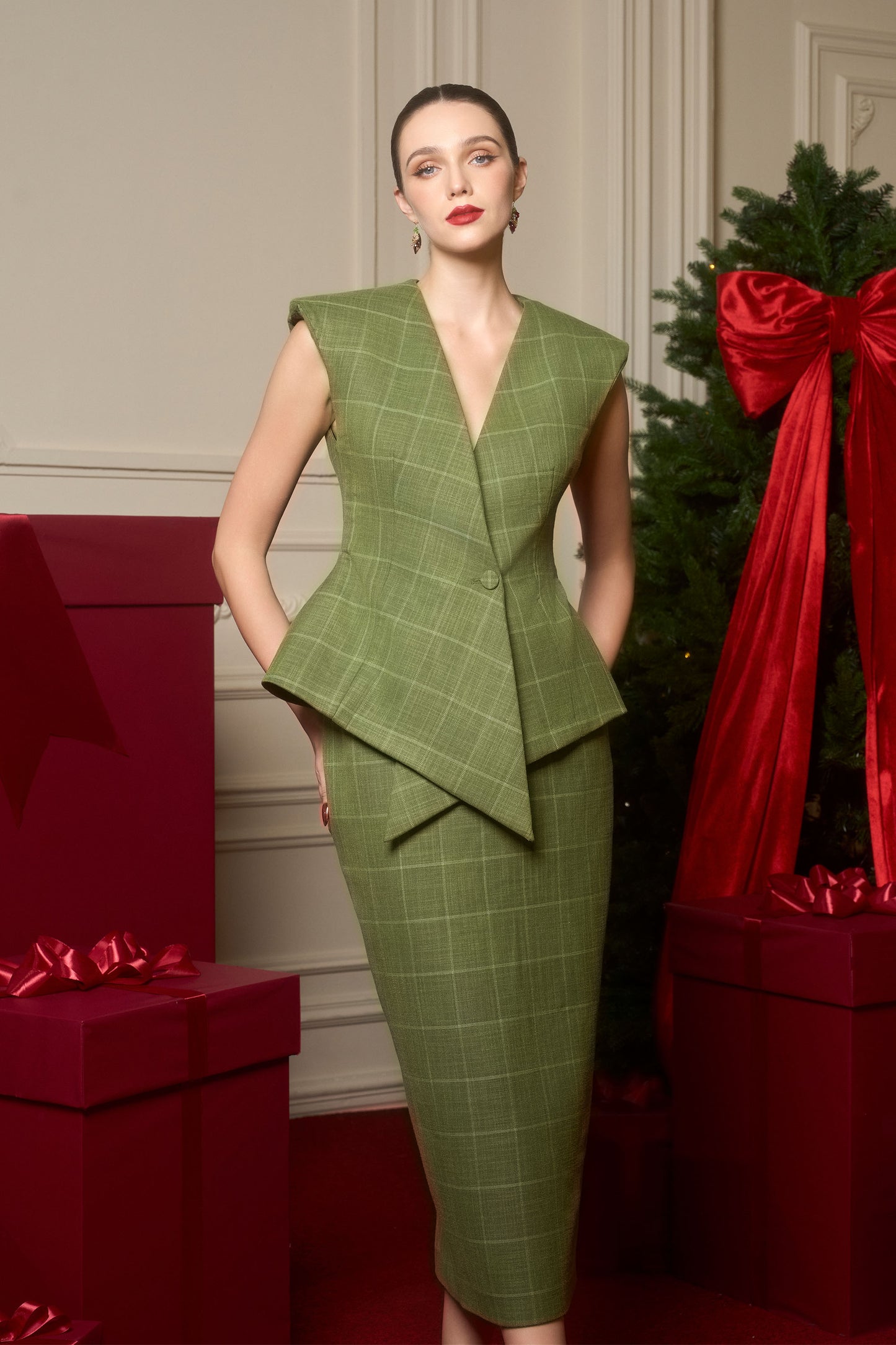 The sleeveless top with a crisscross placket detail, paired with a form-fitting pencil skirt, crafted from premium green tweed.