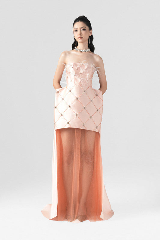 A pink maxi dress in taffeta, featuring a boxy design, feather and stone embellishments, and a floor-length sheer hem.
