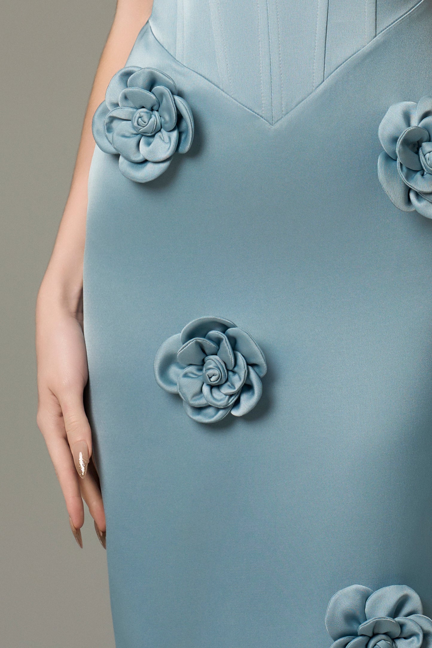 The Turquoise Silk Floral Applique Maxi Dress is crafted from high-quality silk, featuring hand-sewn 3D floral appliqués cascading down the skirt