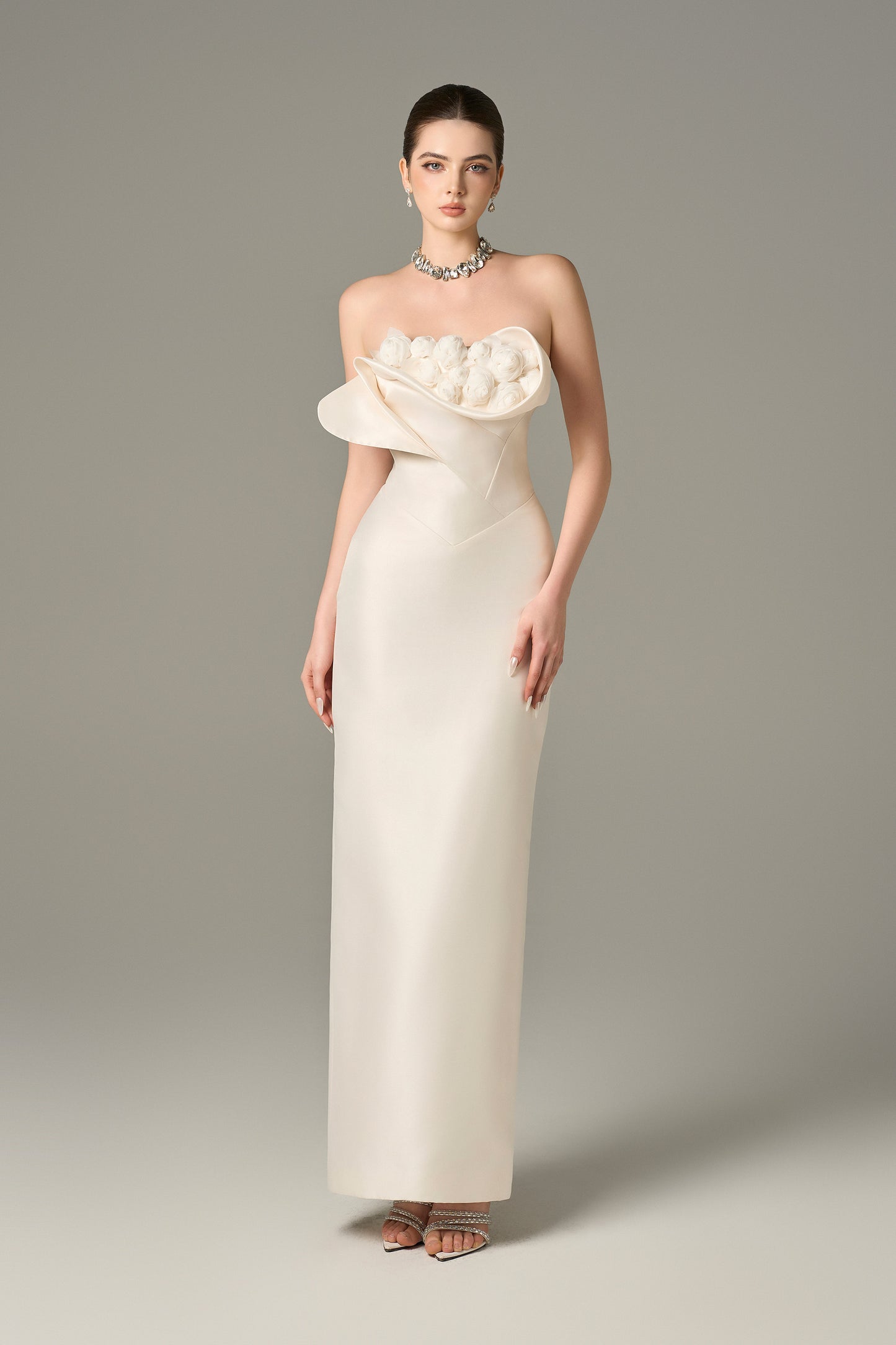 The White Floral Embellished Maxi Dress with a strapless bodice and delicate hand-sewn floral details.