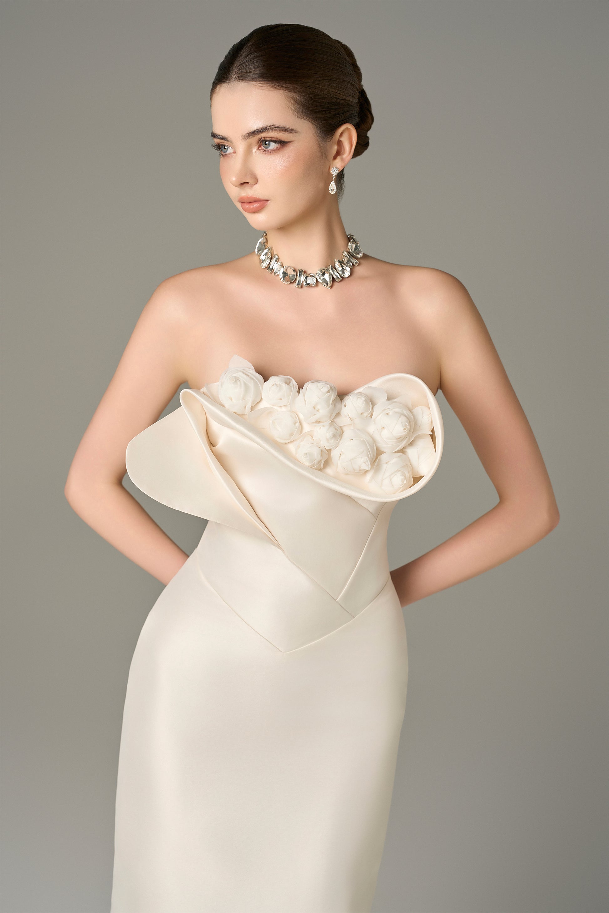 The White Floral Embellished Maxi Dress with a strapless bodice and delicate hand-sewn floral details.