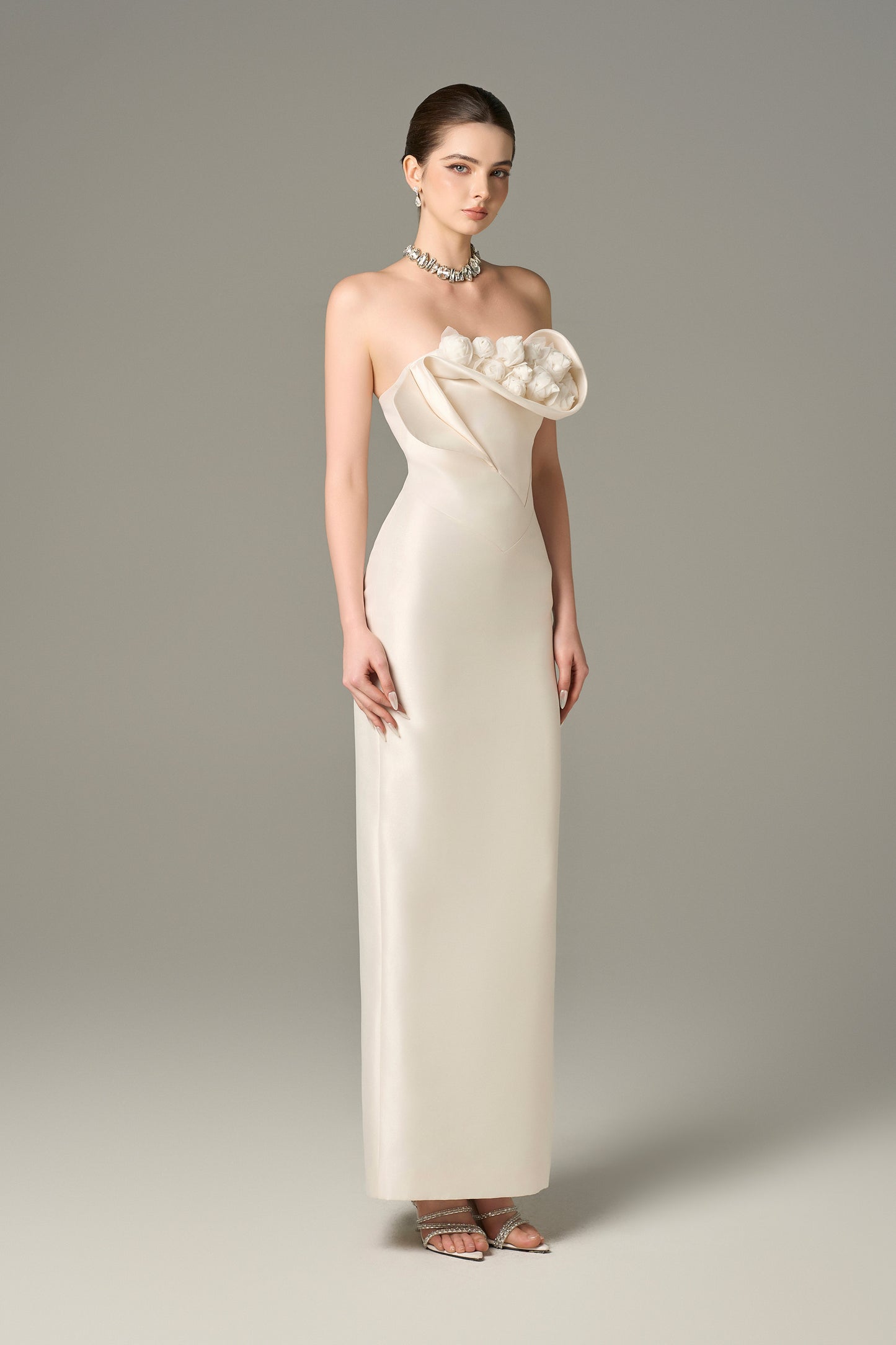 The White Floral Embellished Maxi Dress with a strapless bodice and delicate hand-sewn floral details.