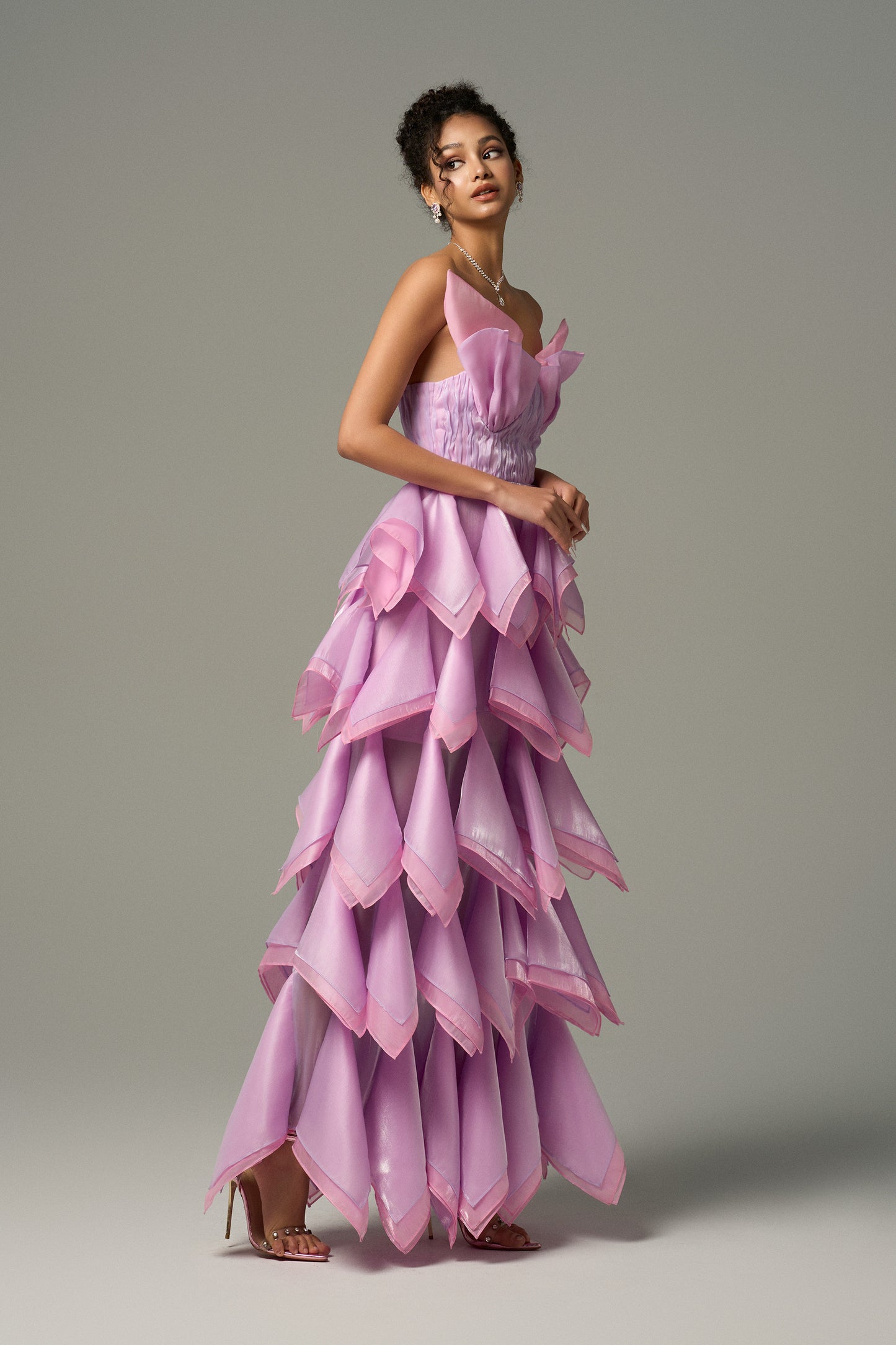 Strapless maxi dress features a sculpted bodice that hugs the waist and a flowing, layered skirt.
