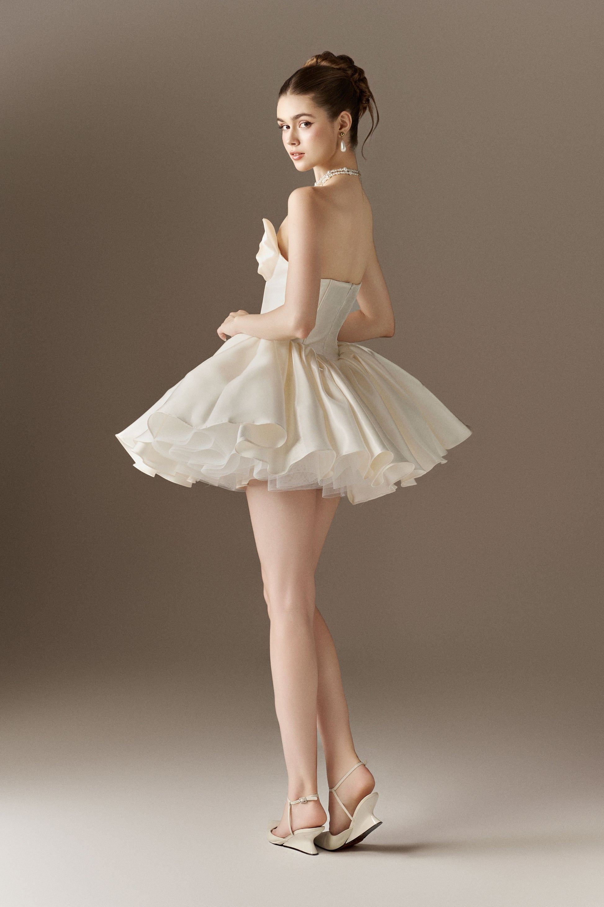 Strapless ivory mini dress with halter neckline, fitted corset bodice and billowing skirt.
