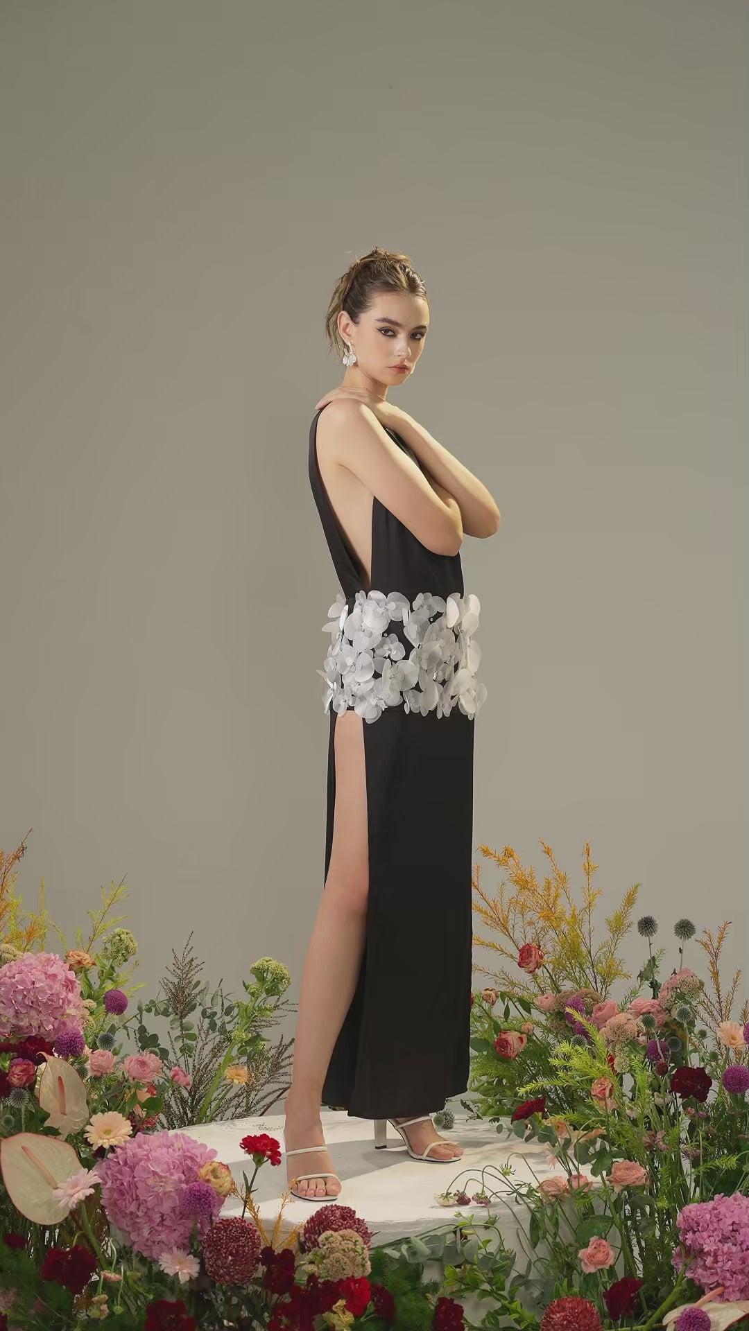 The  black silk dress with boat neckline, thigh-high slits, and handcrafted orchids.