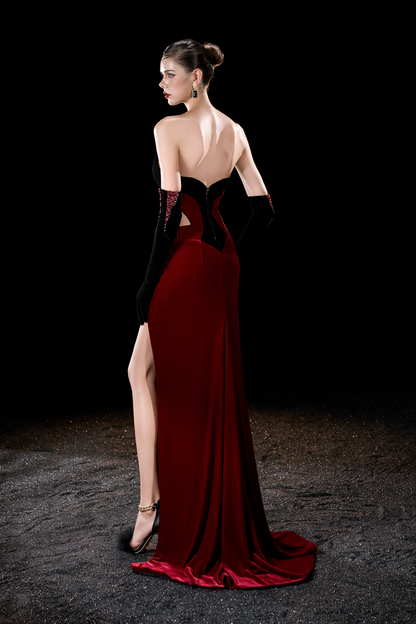 Woman wearing a red and black evening gown with a high slit