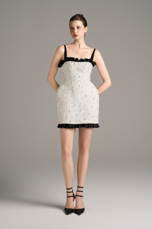 Woman wearing a white lace dress with black trim