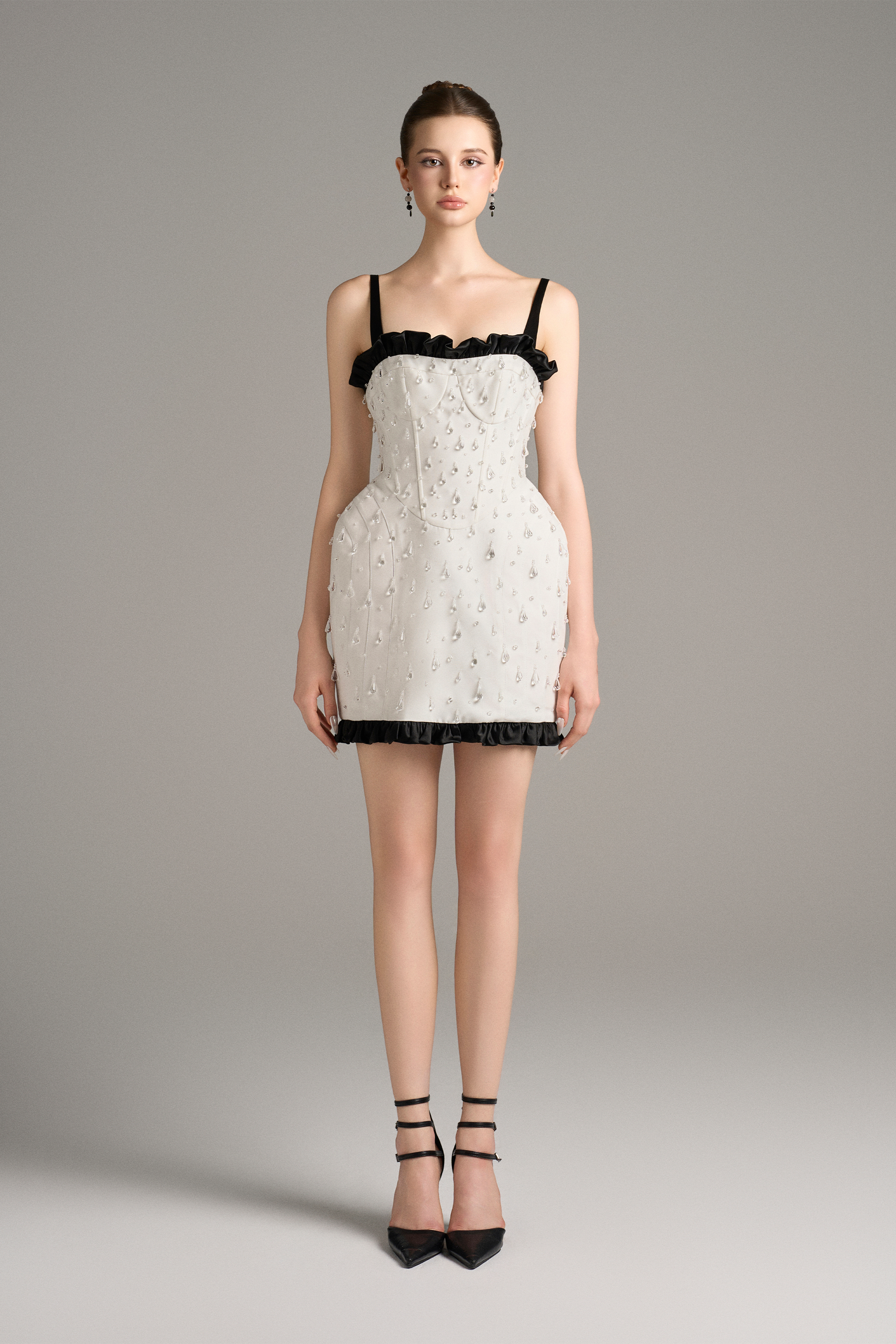 White lace dress with black trim worn by a model