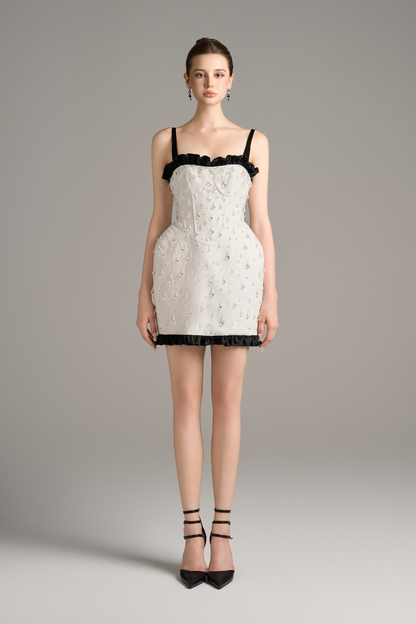 White lace dress with black trim worn by a model