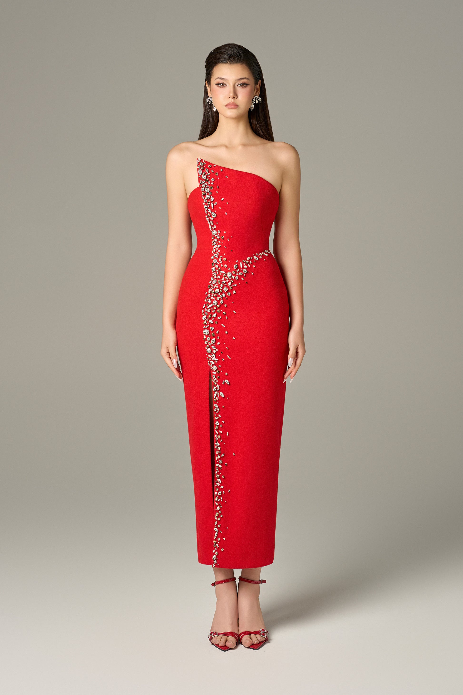 Red maxi dress in felt, with a strapless neckline, crystal embellishments and a thigh-high slit.