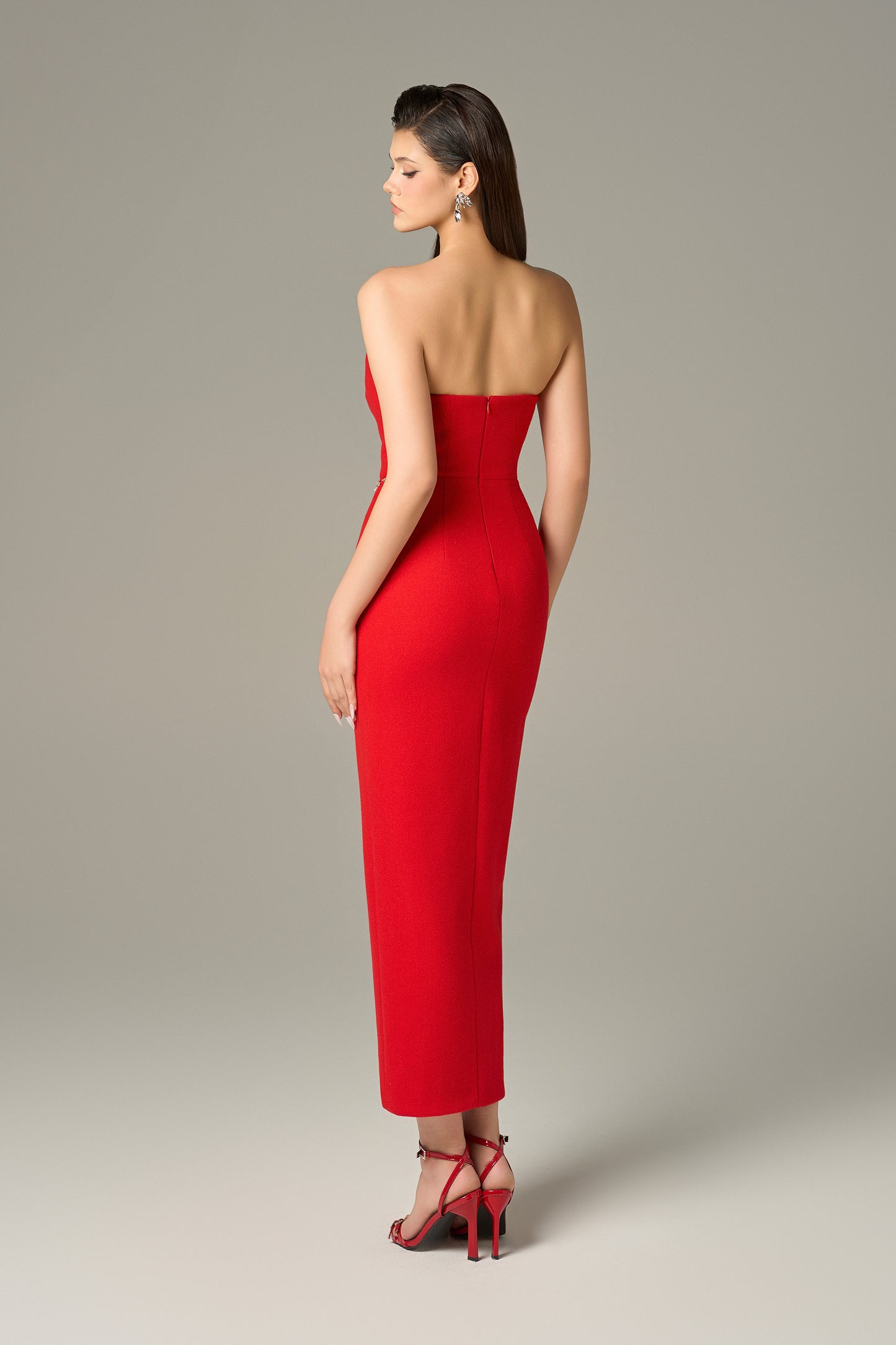 Red maxi dress in felt, with a strapless neckline, crystal embellishments and a thigh-high slit.