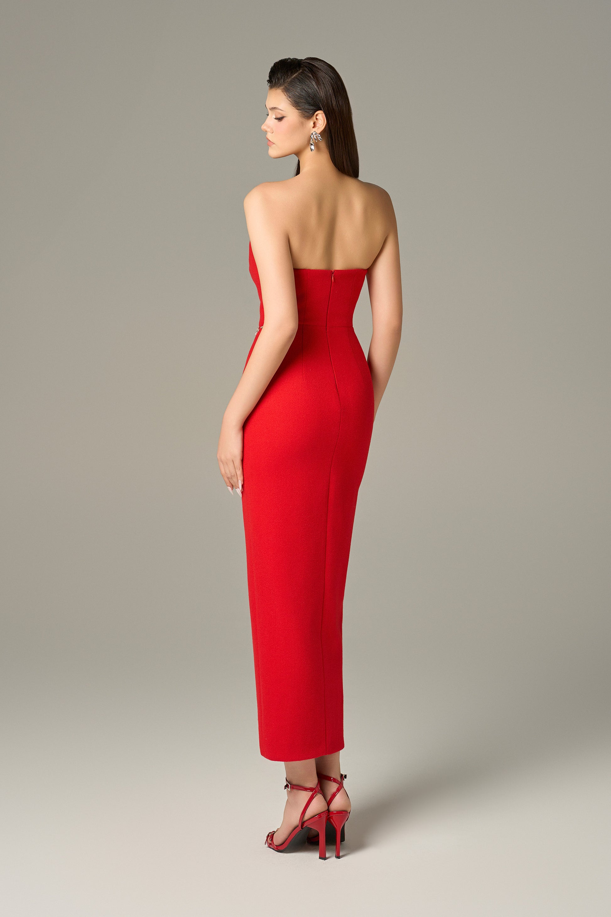 Red maxi dress in felt, with a strapless neckline, crystal embellishments and a thigh-high slit.