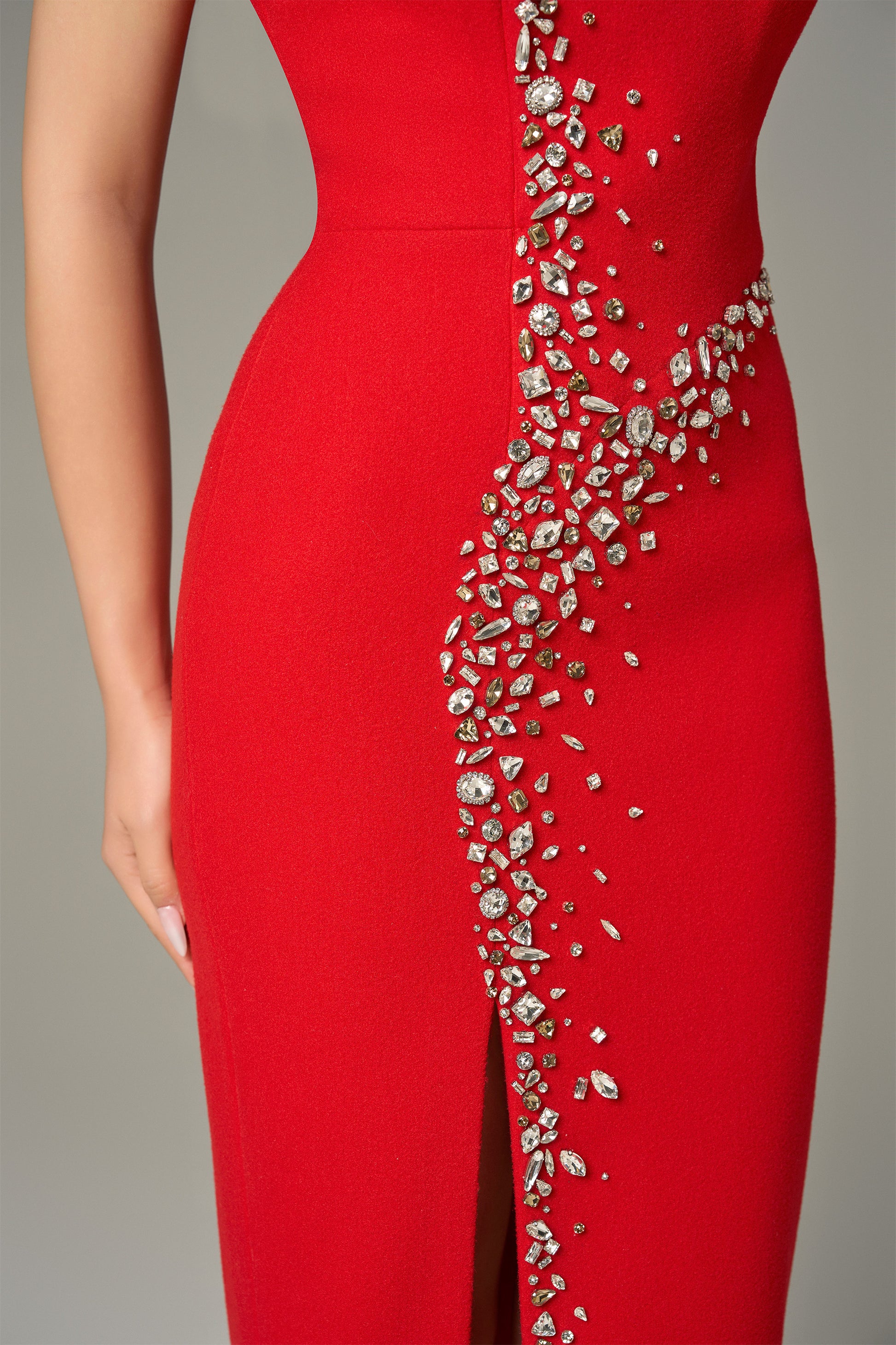 Red maxi dress in felt, with a strapless neckline, crystal embellishments and a thigh-high slit.