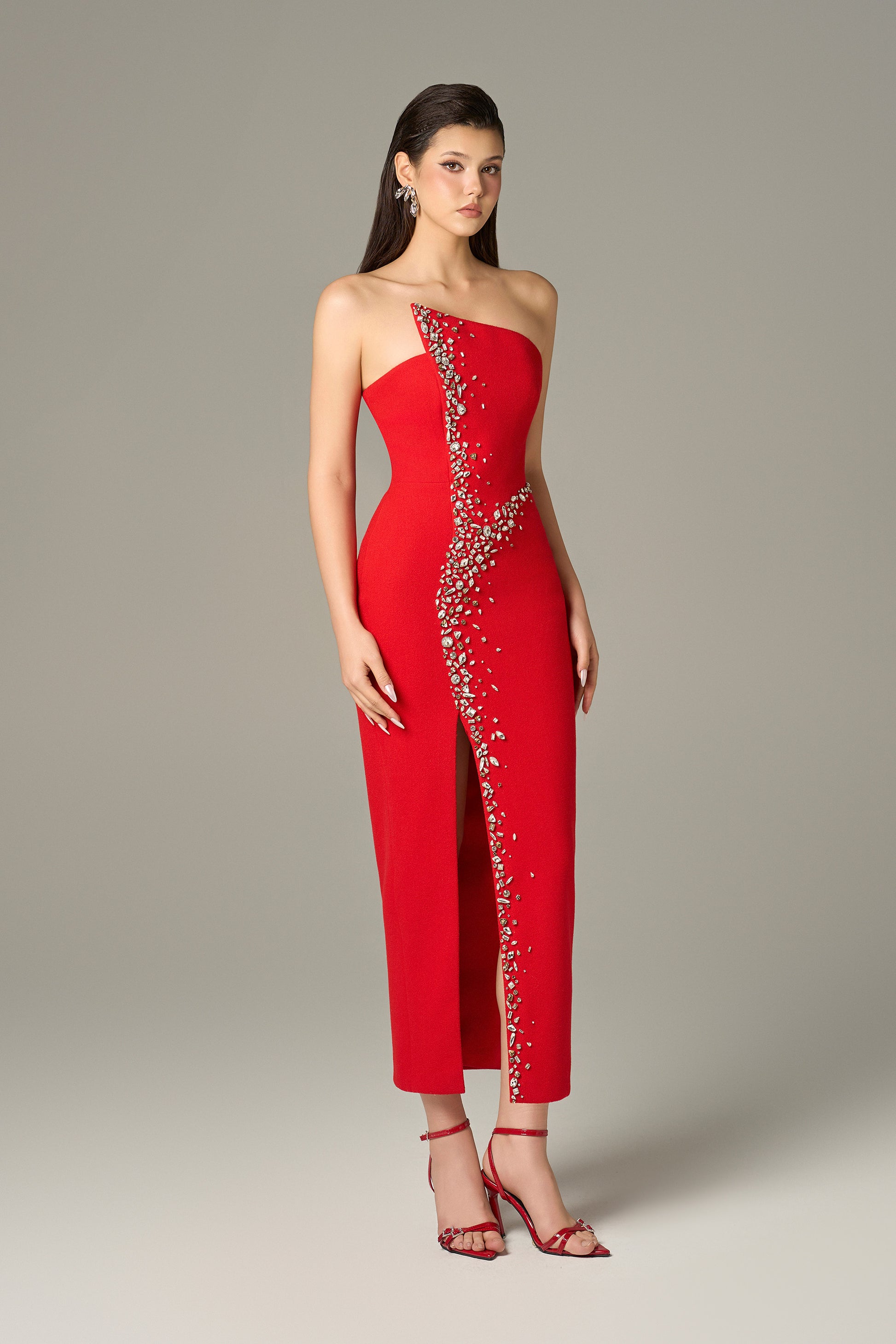Red maxi dress in felt, with a strapless neckline, crystal embellishments and a thigh-high slit.
