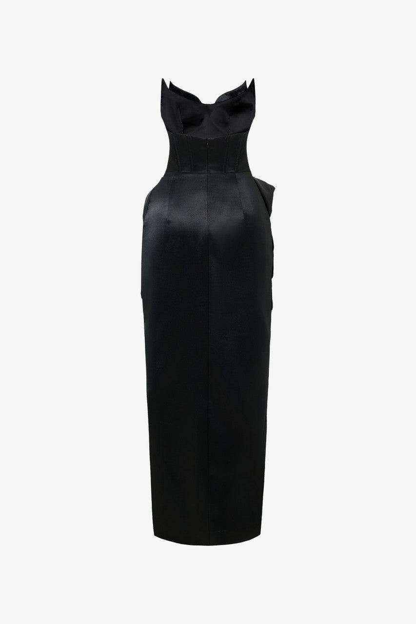 A black dress, featuring a bold side slit, a crystal-embellished neckline, and asymmetrical draping at the waist.