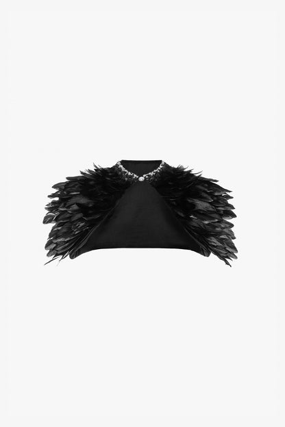 A black feather-adorned cape adds drama and elegance.