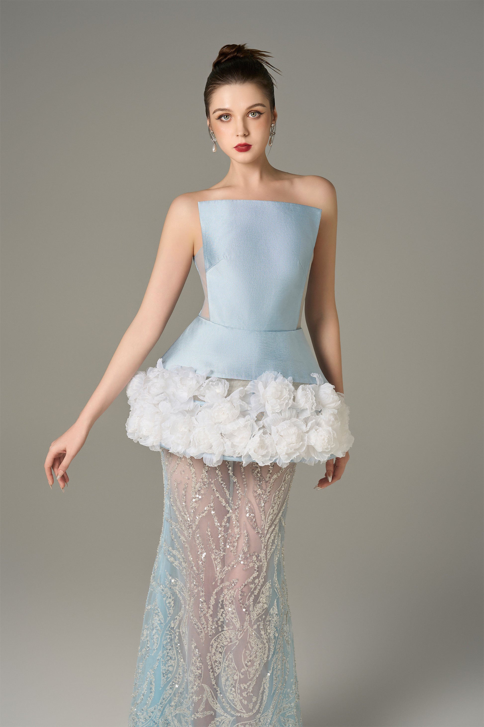 The Blue Gown stuns with a strapless bodice and shimmering lace skirt and handcrafted floral appliqués.