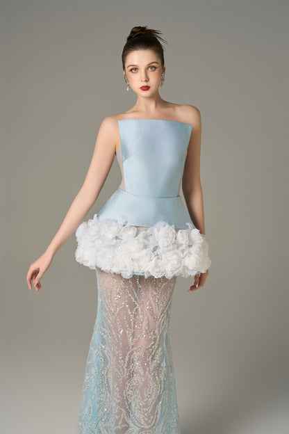 The Blue Gown stuns with a strapless bodice and shimmering lace skirt and handcrafted floral appliqués.