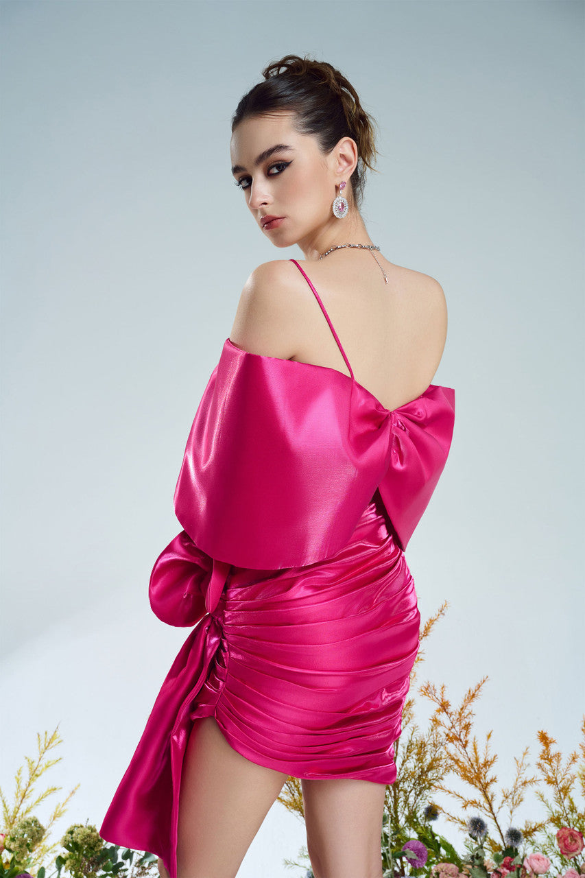A bow-shaped crop top paired with a ruffle trim draped skirt. Available in rich red and pink.