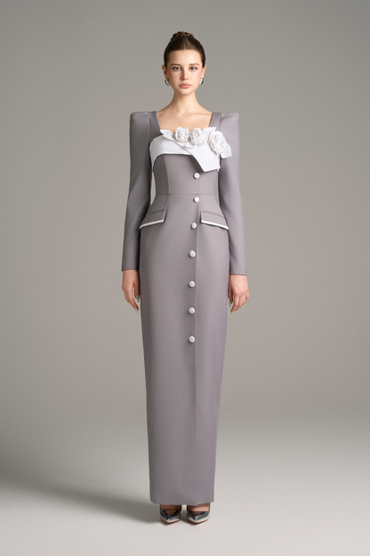 Woman wearing a long, buttoned gray dress with a white top