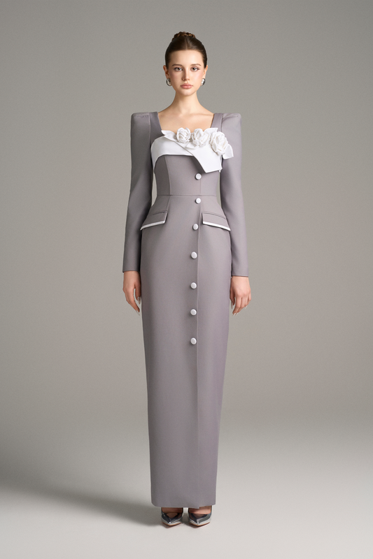 Woman wearing a long, buttoned gray dress with a white top