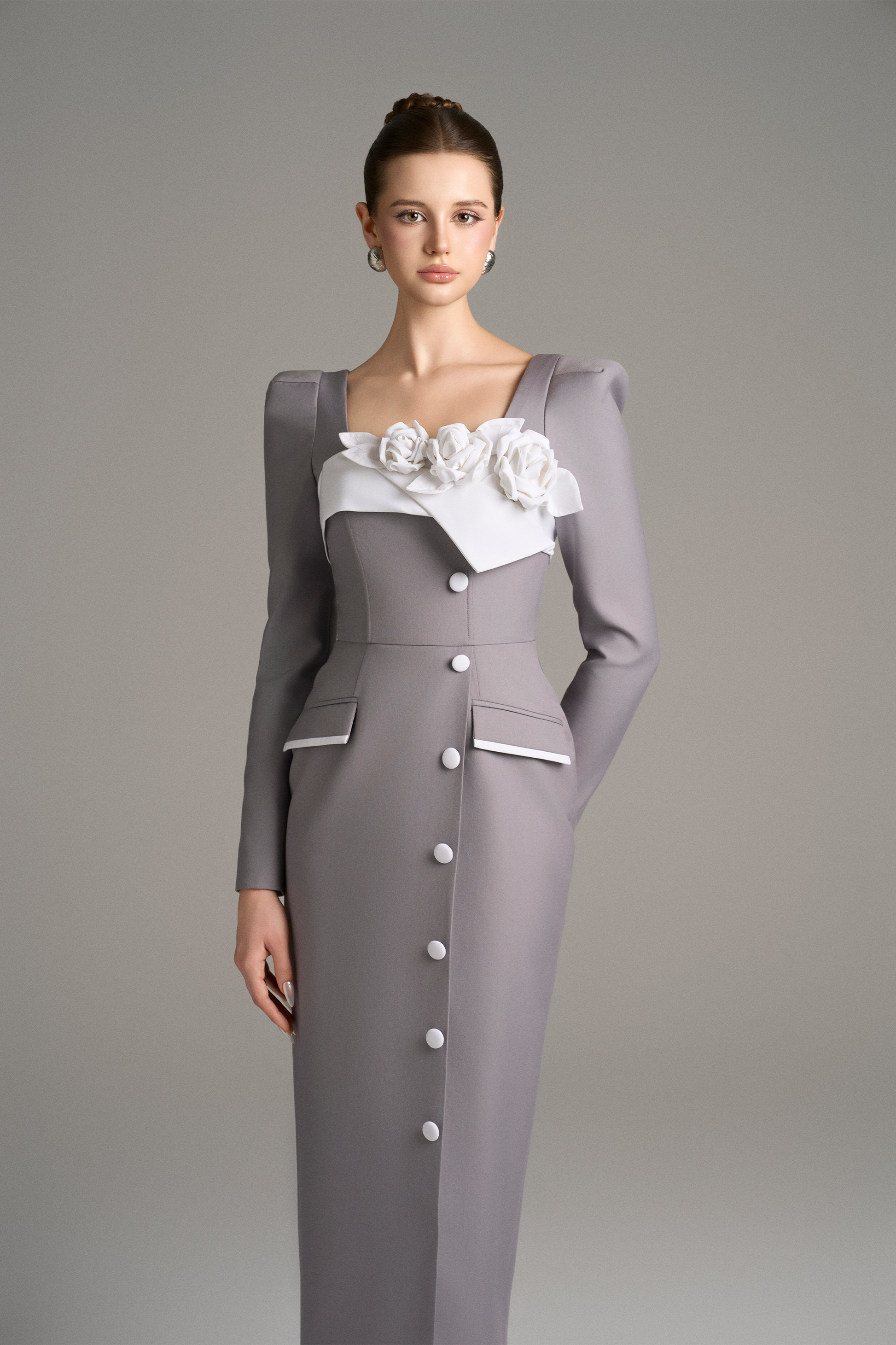 Woman wearing a gray dress with white floral details