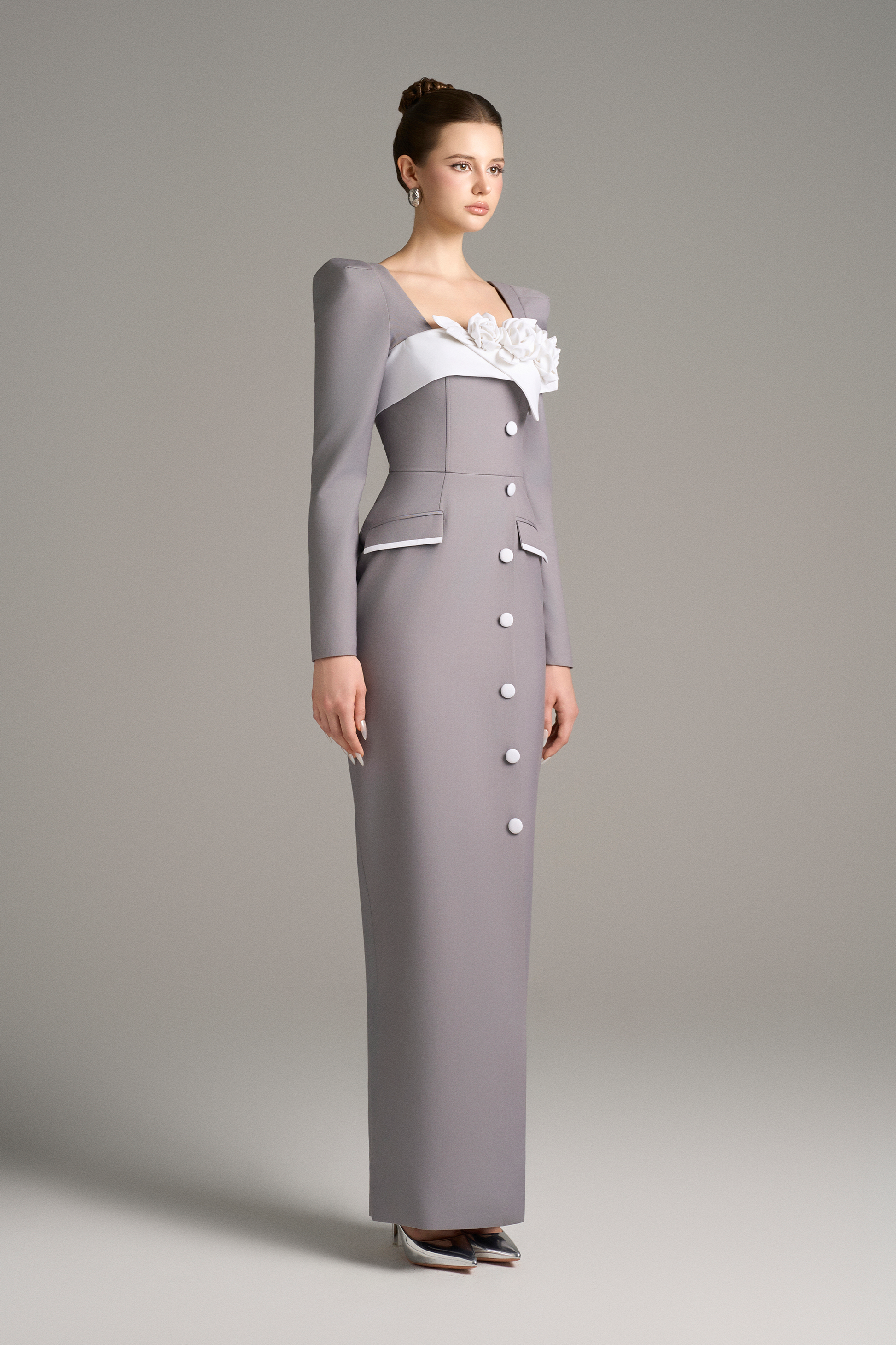 Woman wearing a gray dress with a white floral detail 