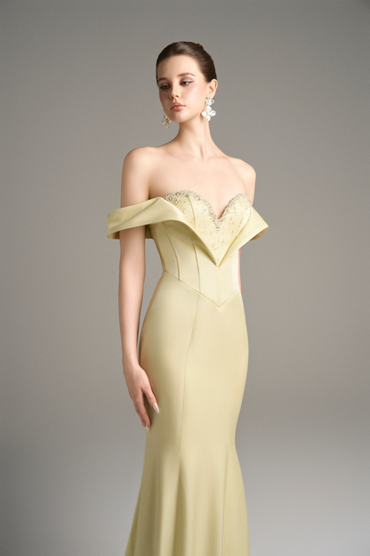 Close-up of a model in a yellow off-shoulder moiré silk gown, highlighting the sweetheart neckline, crystal beaded embellishments, and corset bodice.
