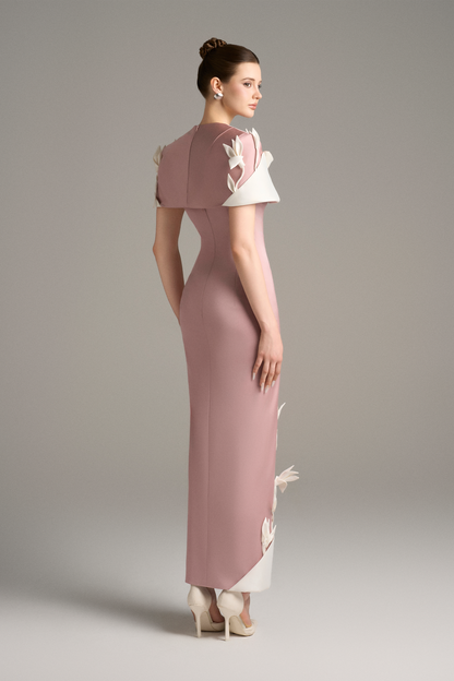 Woman wearing a long, elegant dress with floral details 