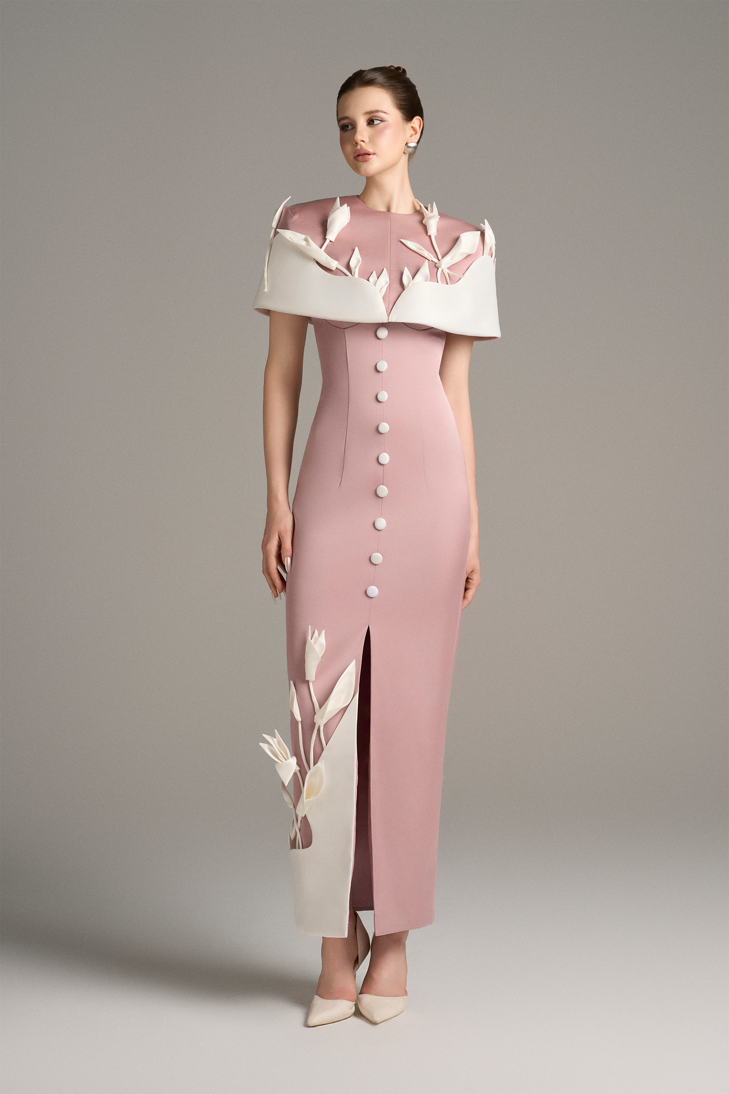 Woman wearing a pink dress with a white collar and floral design