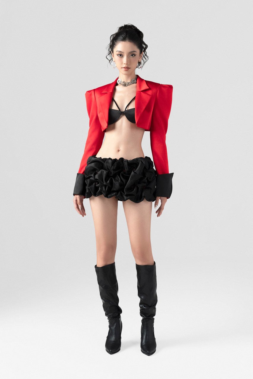 a red crop blazer and a draped black mini skirt with a crystal embellished belt. 