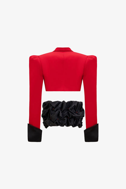a red crop blazer and a draped black mini skirt with a crystal embellished belt. 