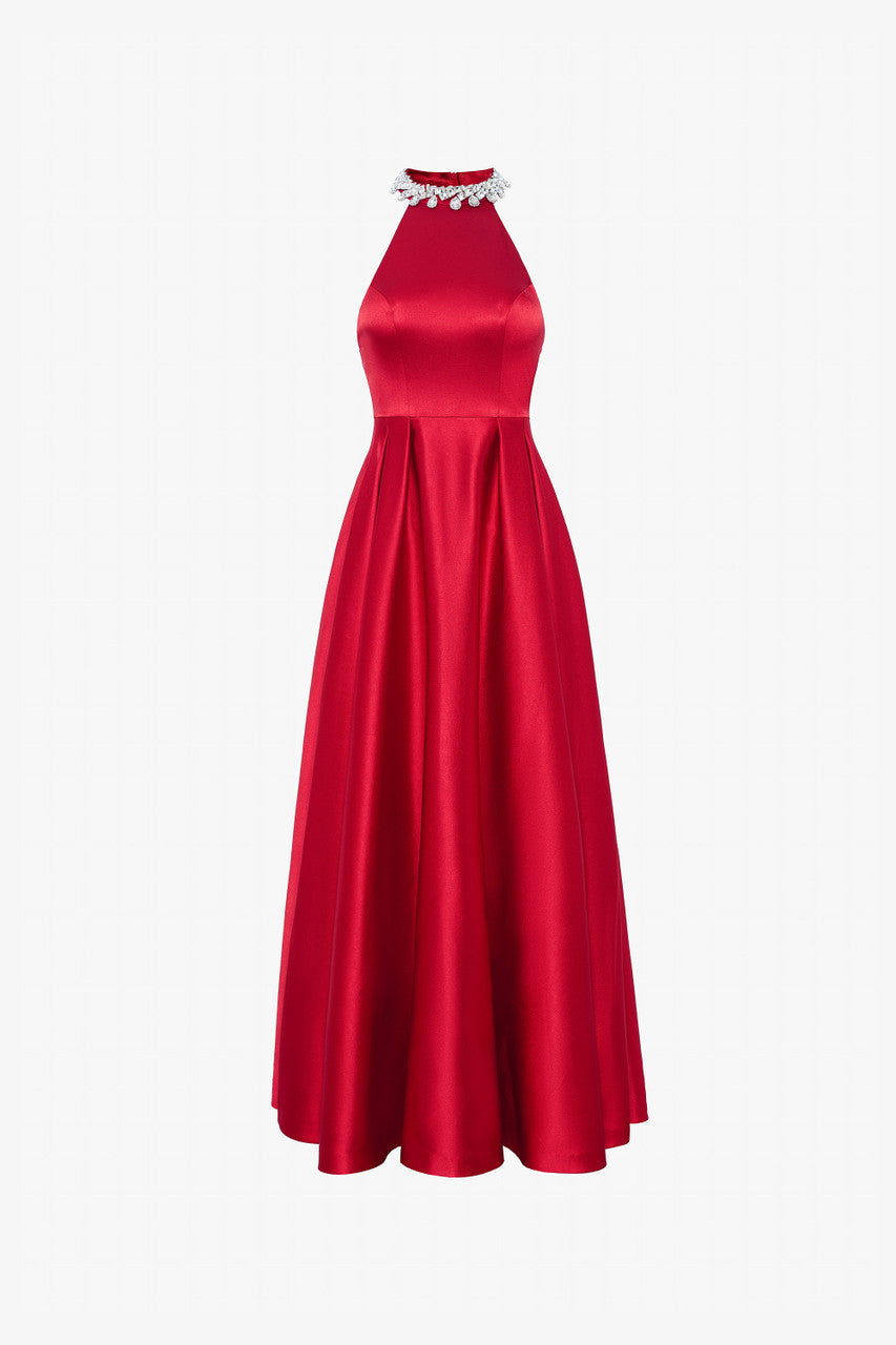 A red silk dress with a fitted halter neck bodice with intricate embellishments and a flowing, flared skirt. 