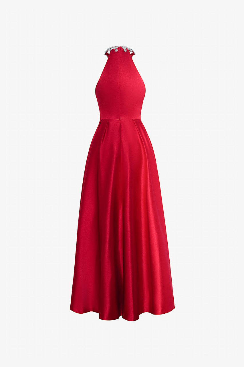A red silk dress with a fitted halter neck bodice with intricate embellishments and a flowing, flared skirt. 