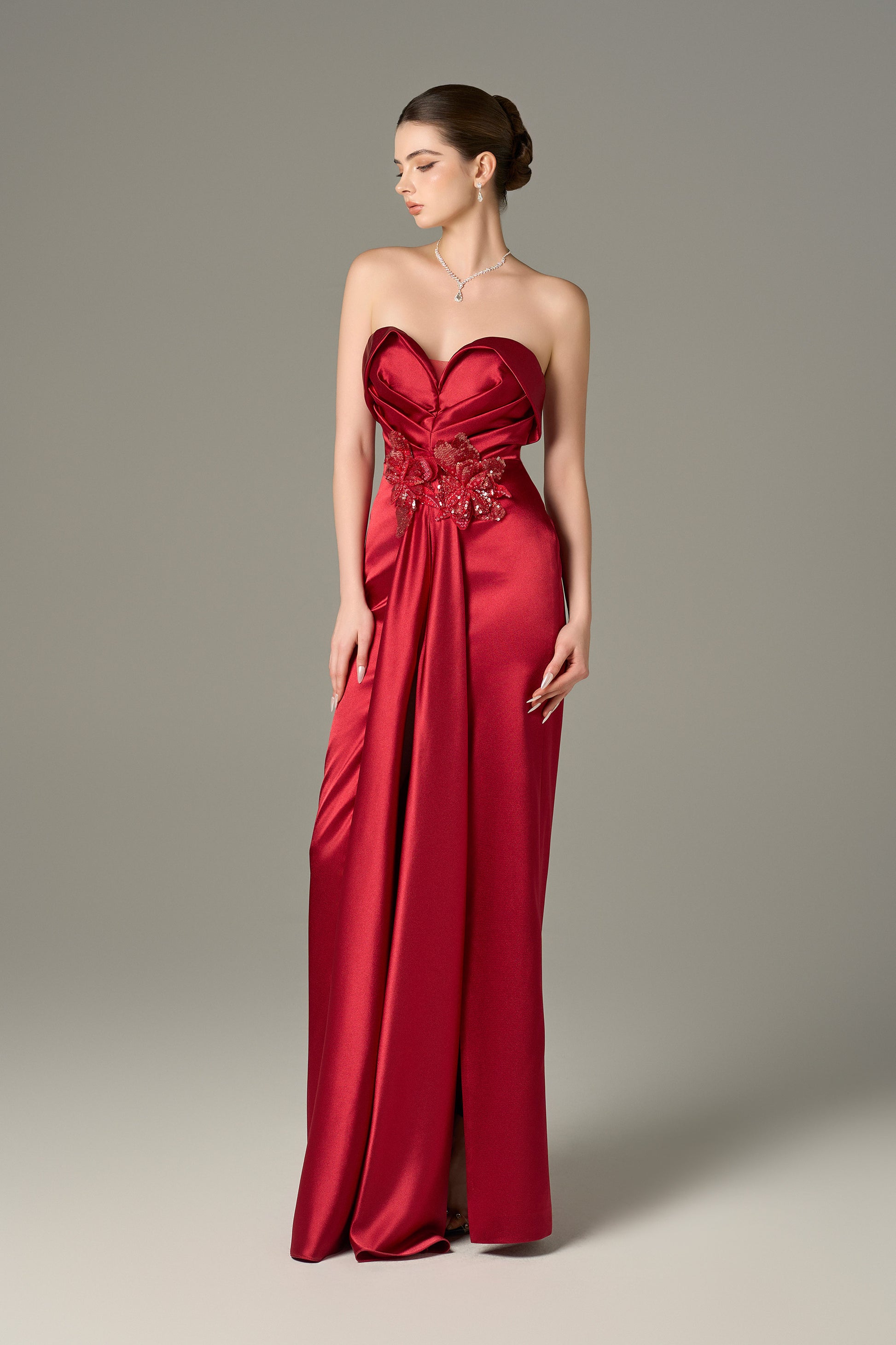 The Red Satin Silk Maxi Dress stuns with a 3D pleated heart bodice, sequin floral details and a  thigh-high slit.