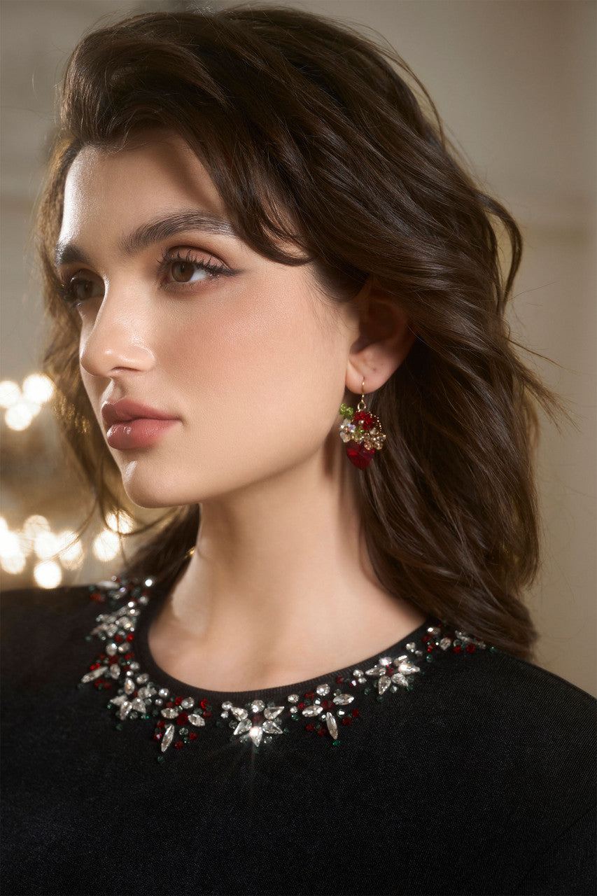 A sleek black fitted top with a beaded round neckline and cut-out back, and a red skirt adorned with an oversized bow. 