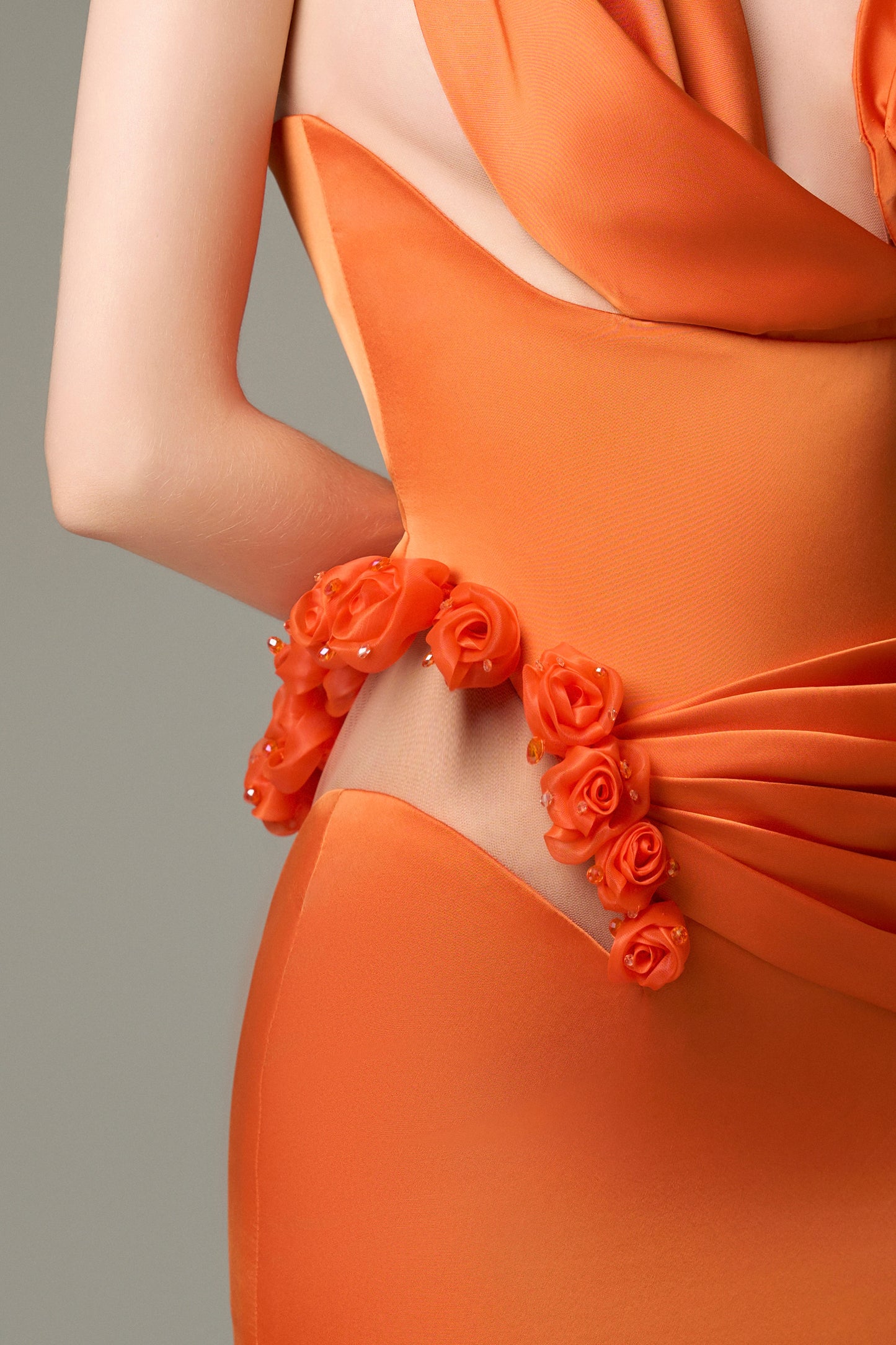 The Elegant Silk Floral Bust Draped Maxi Dress in Orange features delicate flower sculpted on one side.