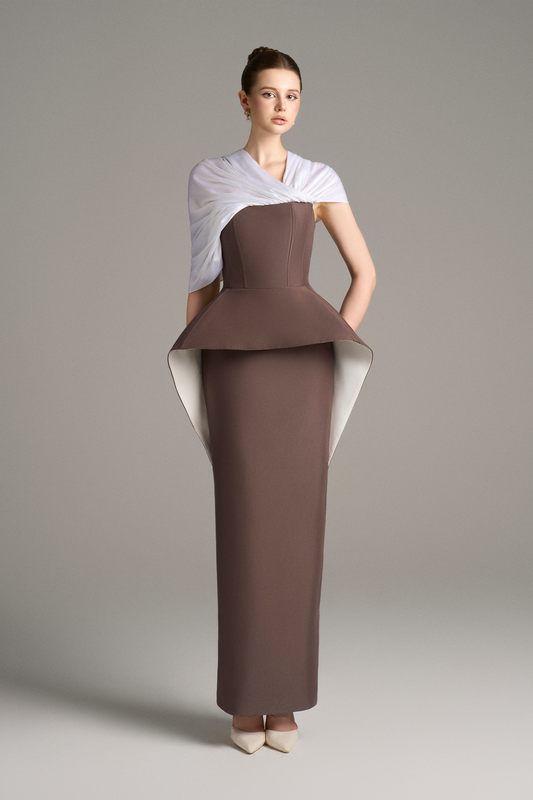 Front view of strapless column gown with structured peplum detail and draped white shoulder wrap