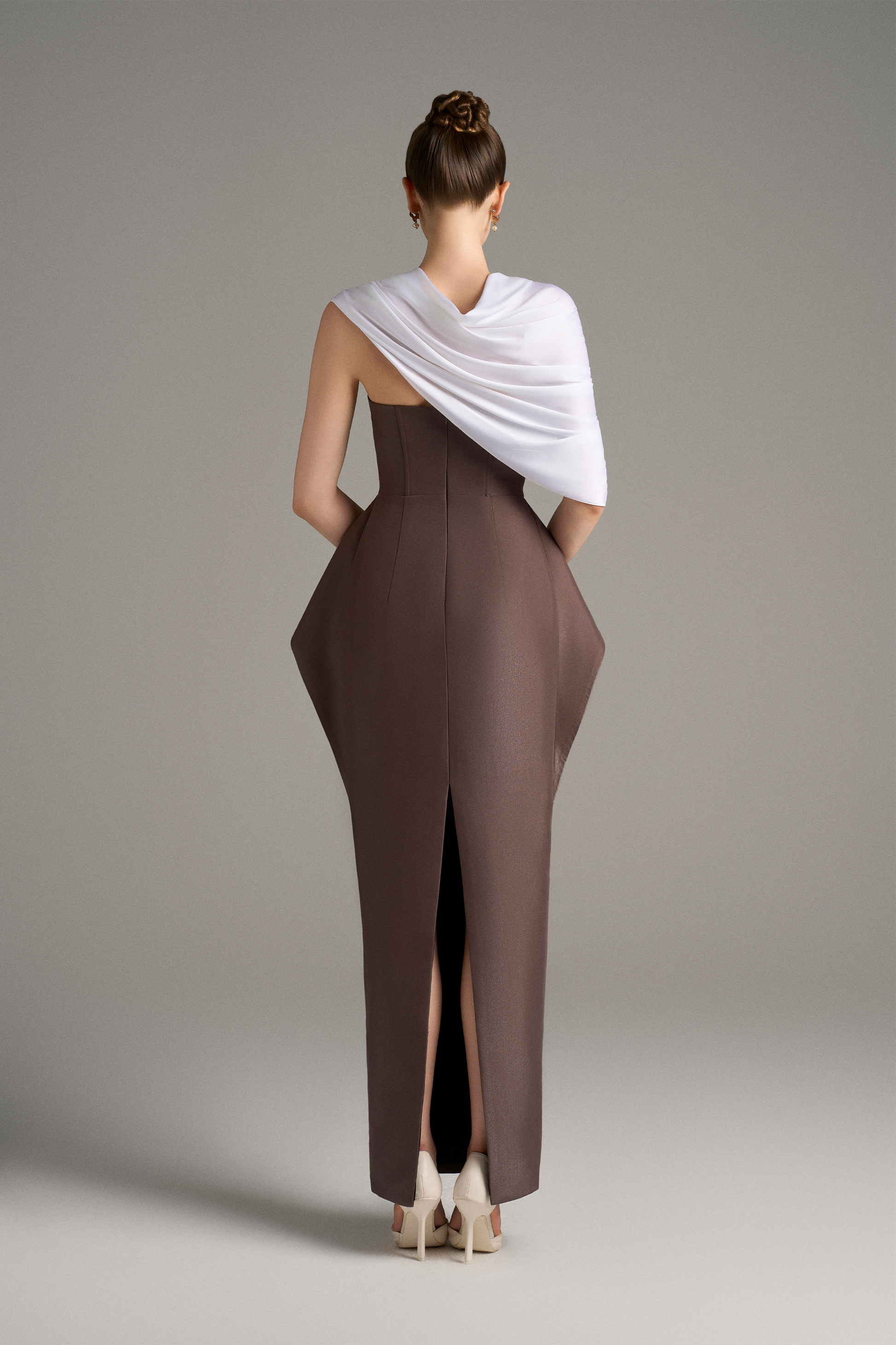 Back view of strapless column gown with structured peplum detail and draped white shoulder wrap
