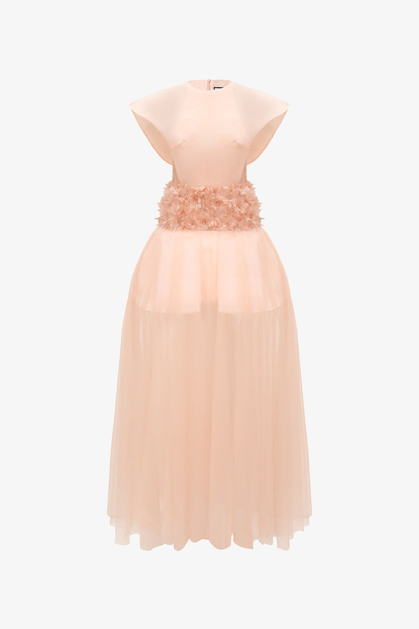 The pink maxi dress in organza, featuring wing sleeves, floral-embellished waist, and floor-length see-through ruffle hem. 