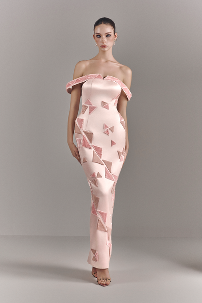 Model wearing a pink strapless dress with geometric pattern on a gray background