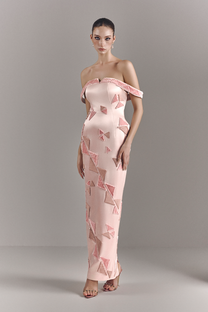 Model wearing a pink off-shoulder dress with geometric pattern on a gray background