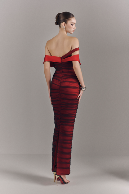 Woman wearing a red and black striped evening gown against a neutral background
