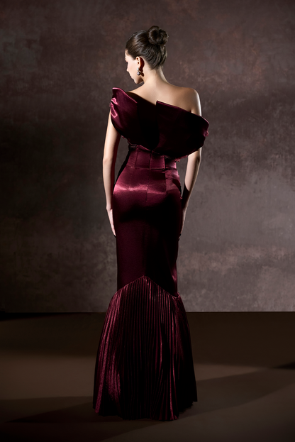 Woman wearing a burgundy evening gown against a dark background
